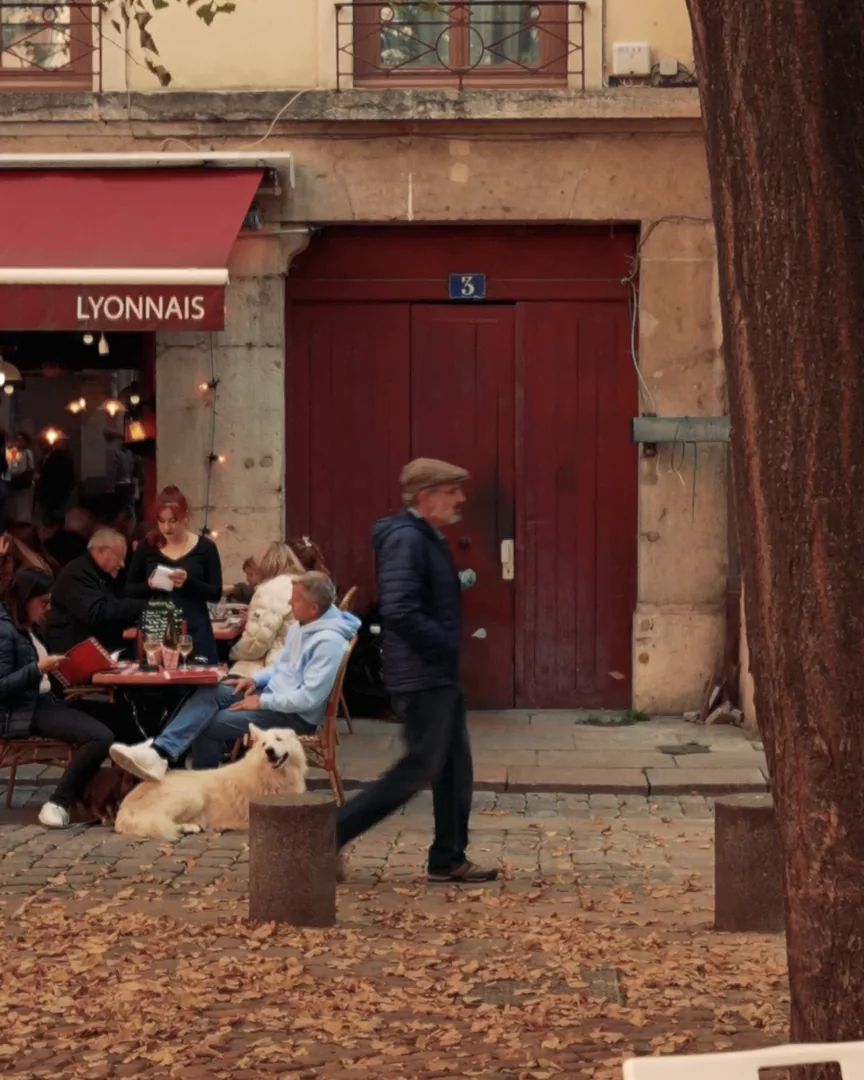 Une rue du Vieux-Lyon en automne, terrasse d’un bouchon et passants