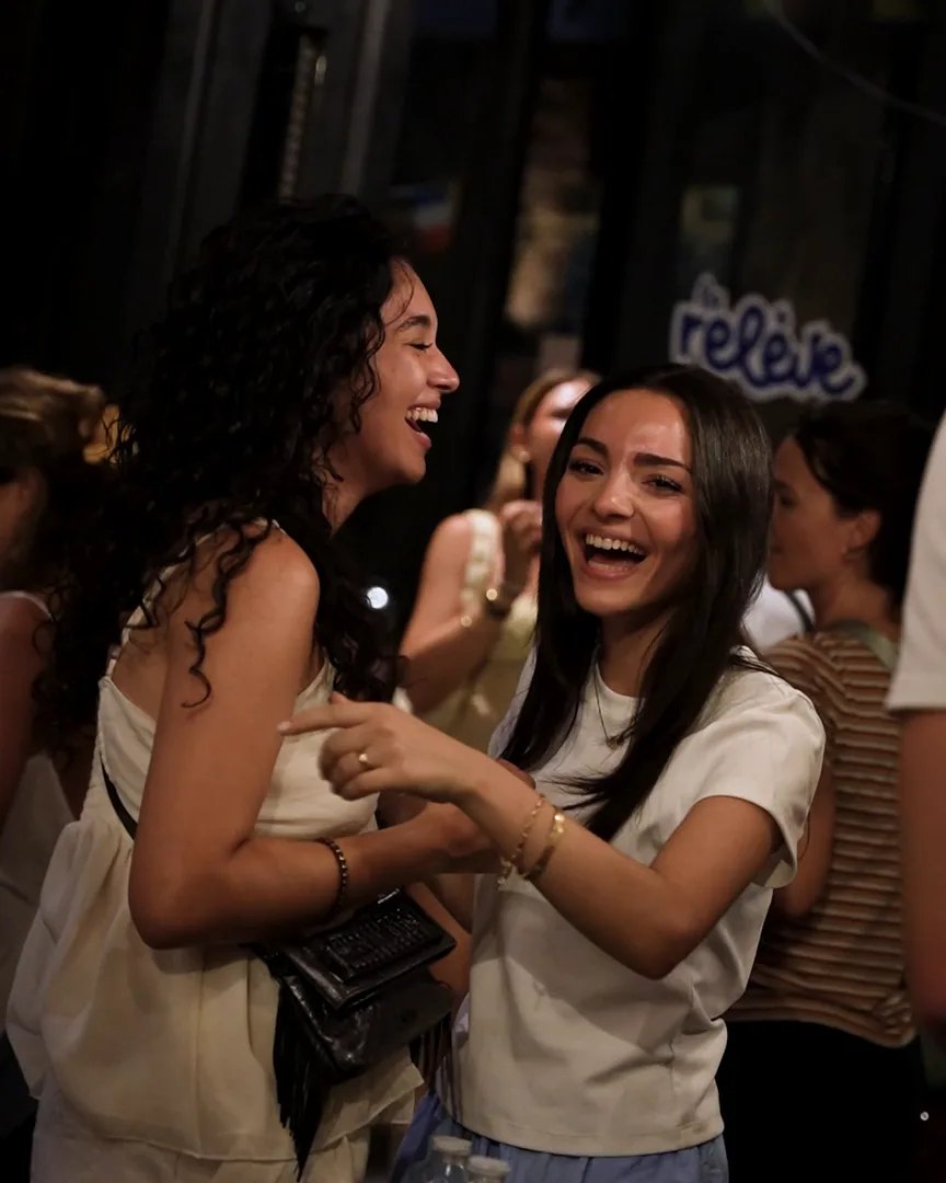 Deux amies rient pendant la Fête de la musique 2026 avec Horison au bar La Relève